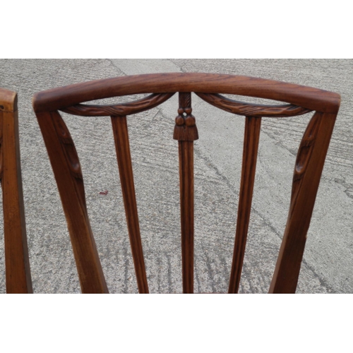 409 - A set of four early 19th century fruitwood dining chairs with swag carved vertical rail backs and st... 