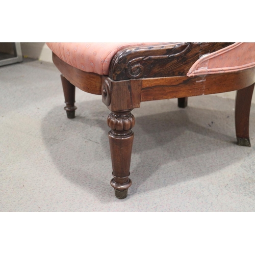 419 - A 19th century rosewood showframe low seat nursing chair, upholstered in a pink fabric, on turned su... 