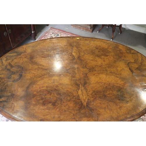 421 - A mid Victorian figured walnut oval loo table, on carved column and four scroll supports, 58