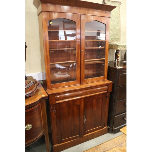 453 - A mid 19th century mahogany bookcase, the upper section enclosed two arch top glazed doors, over one... 