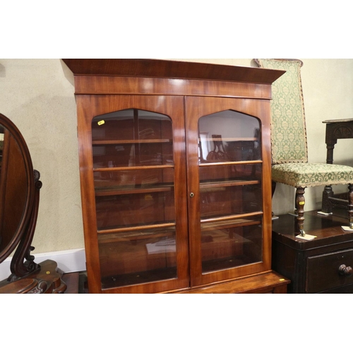 453 - A mid 19th century mahogany bookcase, the upper section enclosed two arch top glazed doors, over one... 