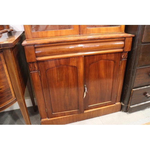 453 - A mid 19th century mahogany bookcase, the upper section enclosed two arch top glazed doors, over one... 