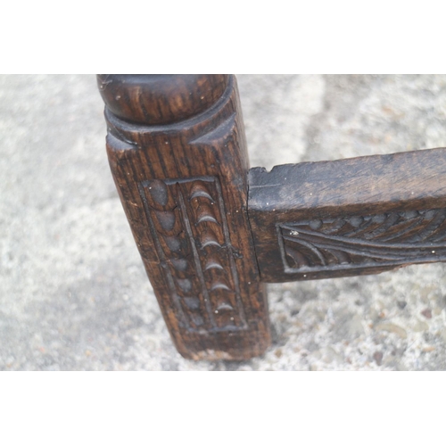 454 - An antique carved oak joint stool of 17th century design with carved decoration, on turned supports,... 