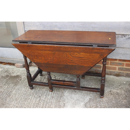 462 - An antique oak gateleg drop leaf dining table, on turned and stretchered supports, 46