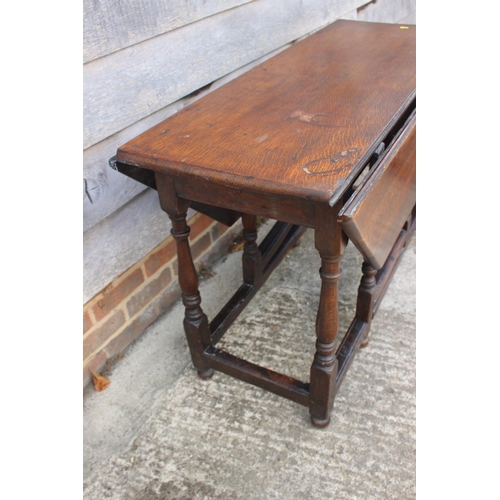 462 - An antique oak gateleg drop leaf dining table, on turned and stretchered supports, 46