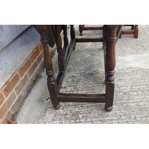 462 - An antique oak gateleg drop leaf dining table, on turned and stretchered supports, 46