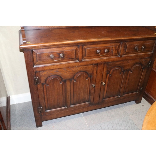 486 - An oak dresser, the upper section fitted two cupboards and open shelves, over three drawers and cupb... 