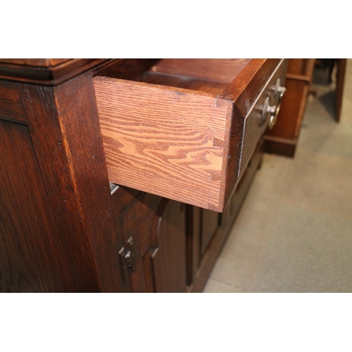 486 - An oak dresser, the upper section fitted two cupboards and open shelves, over three drawers and cupb... 