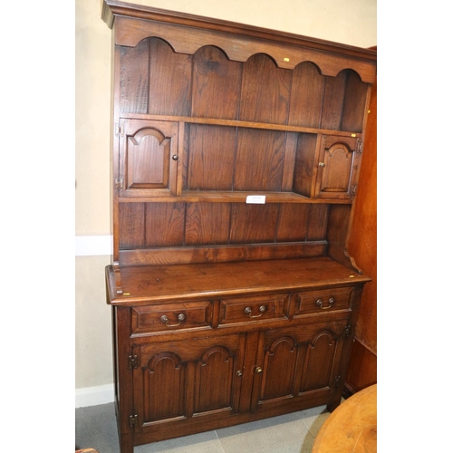 486 - An oak dresser, the upper section fitted two cupboards and open shelves, over three drawers and cupb... 