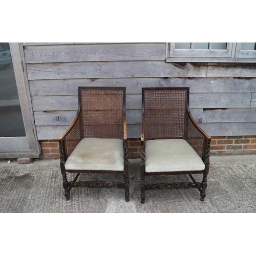 510 - A pair of 1920s polished as walnut bergere armchairs with padded seats, on barley twist stretchered ... 