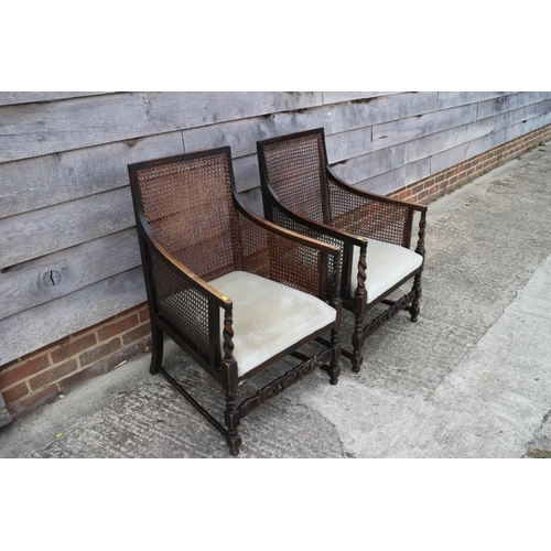 510 - A pair of 1920s polished as walnut bergere armchairs with padded seats, on barley twist stretchered ... 