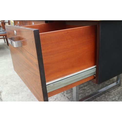 512 - A 1960s Danish rosewood desk, fitted deep drawers, on chrome supports, 62