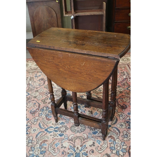 520 - An oak oval drop leaf gateleg table, on turned and stretchered supports, 25 1/2