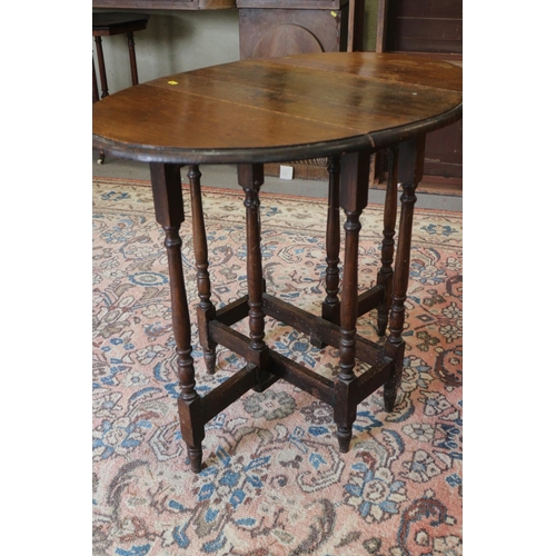 520 - An oak oval drop leaf gateleg table, on turned and stretchered supports, 25 1/2