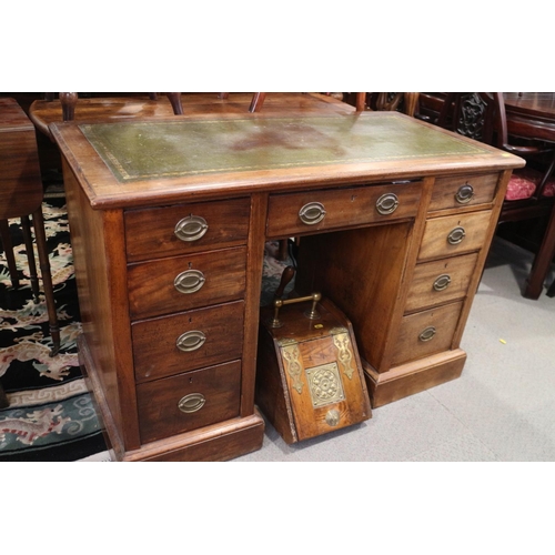 522 - An Edwardian mahogany kneehole desk with green leather lined top, over nine drawers with oval brass ... 