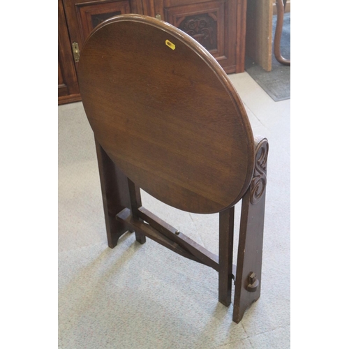 525 - A 1930s walnut circular fold-over top table, on panel end supports, 21