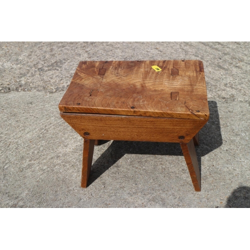 551 - An elm and fruitwood stool, on panel end supports, 10