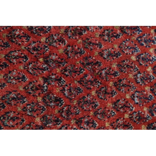 584 - A Persian carpet with all-over boteh design on a red ground, multi-bordered in shades of blue, red, ... 