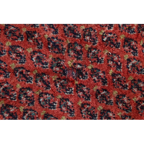 584 - A Persian carpet with all-over boteh design on a red ground, multi-bordered in shades of blue, red, ... 