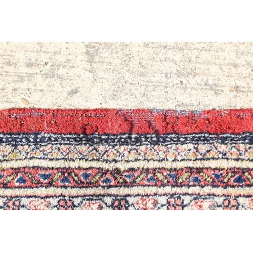 584 - A Persian carpet with all-over boteh design on a red ground, multi-bordered in shades of blue, red, ... 