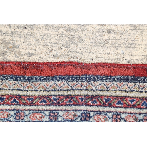 584 - A Persian carpet with all-over boteh design on a red ground, multi-bordered in shades of blue, red, ... 