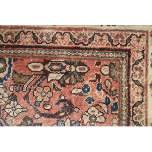 585 - A Persian carpet with all-over Herati design, on a pink ground, in shades of blue, brown and natural... 