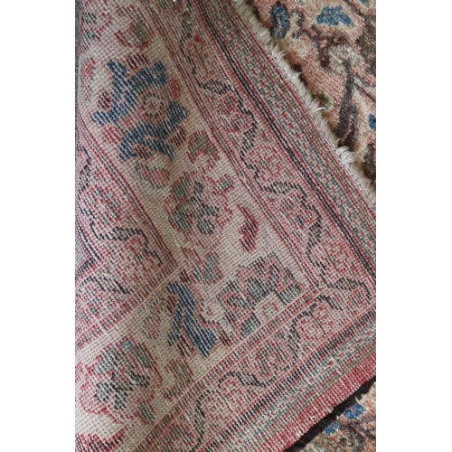 585 - A Persian carpet with all-over Herati design, on a pink ground, in shades of blue, brown and natural... 