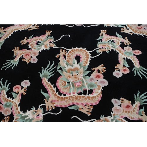 586 - A Chinese circular contour pile rug with dragon design on a black ground, 88