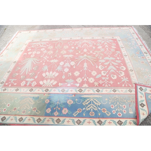 587 - A flat weave carpet of geometric design, in faded shades of blue, pink, green and neutral, 169