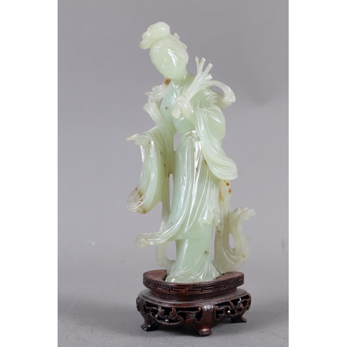 85 - A Chinese jade carving of Kuan-Yin, on wooden base, 8 1/2