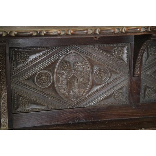 403 - A dark oak shelf with carved panels of Tudor castles, 65