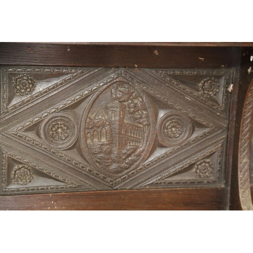 403 - A dark oak shelf with carved panels of Tudor castles, 65