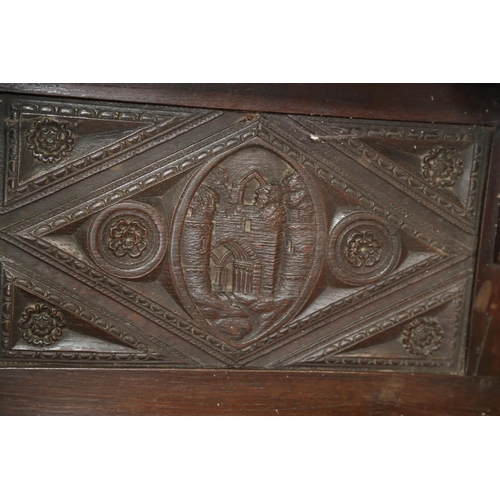 403 - A dark oak shelf with carved panels of Tudor castles, 65