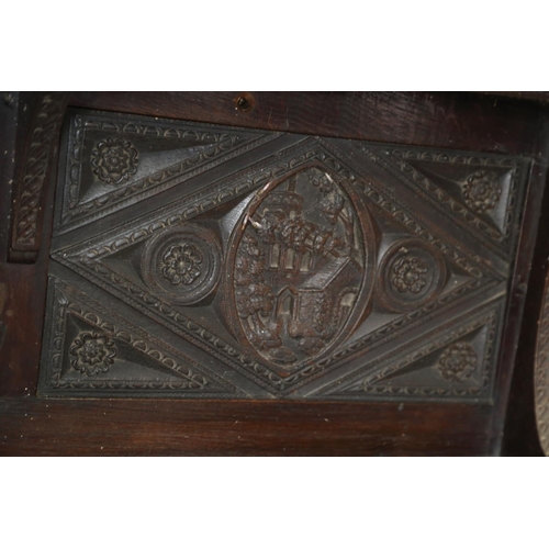 403 - A dark oak shelf with carved panels of Tudor castles, 65