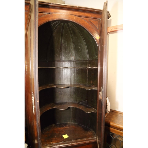 417 - A Georgian oak corner cupboard the upper section with shaped shelves enclosed two arch top panel doo... 