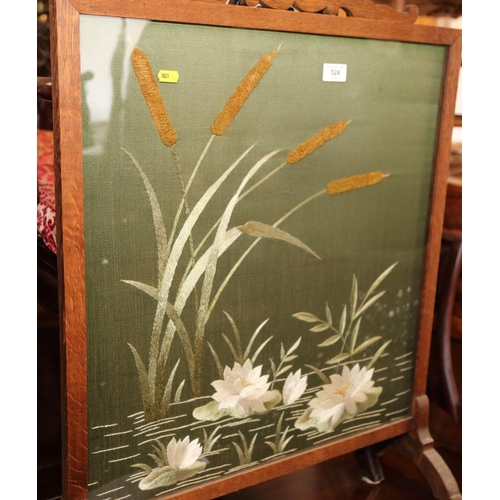 524 - An oak framed firescreen, inset glazed embroidered panel of water plants