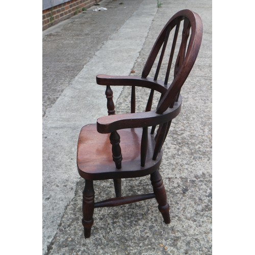 483 - A pair of child's Windsor splat back elbow chairs with panel seat, on turned and stretchered support... 