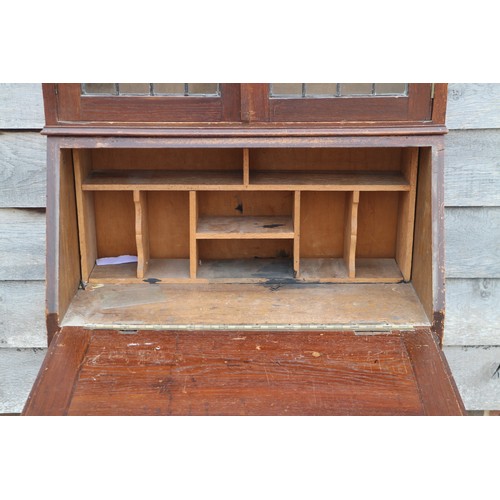 498 - An early 20th century oak bureau bookcase, the upper section enclosed leaded glazed doors, over fall... 