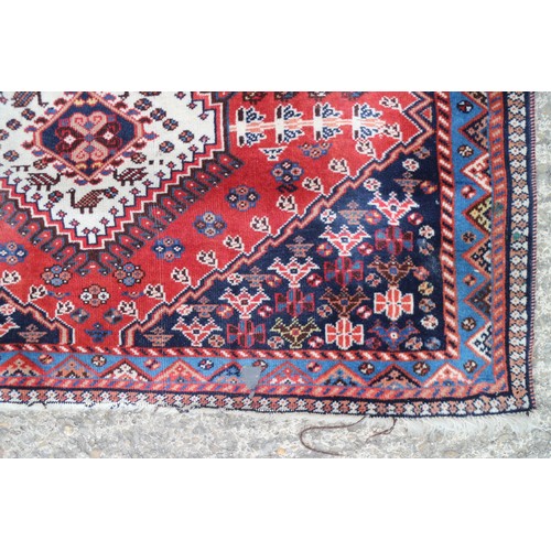 583 - A Caucasian tribal rug with two white and one blue lozenge on a rust ground and multi-bordered in sh... 