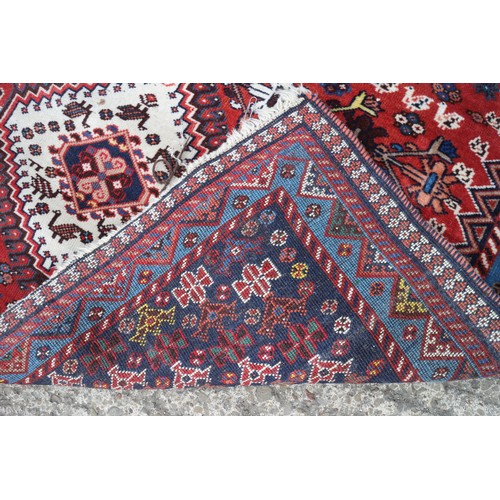 583 - A Caucasian tribal rug with two white and one blue lozenge on a rust ground and multi-bordered in sh... 