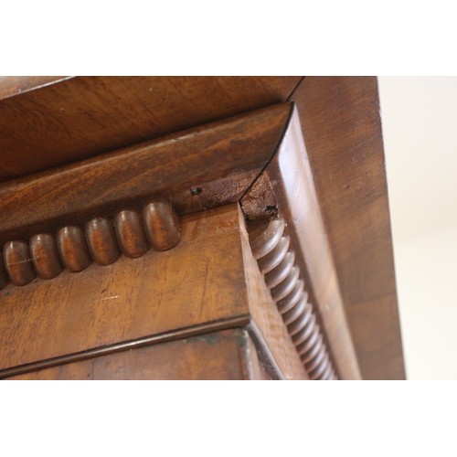 411 - An early 19th century mahogany linen press, the upper section enclosed two doors, over two faux draw... 