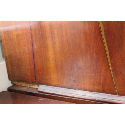 411 - An early 19th century mahogany linen press, the upper section enclosed two doors, over two faux draw... 