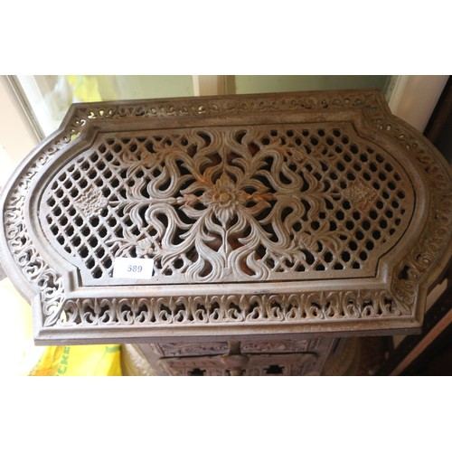 589 - A grey painted cast iron stove with pierced decoration, on cabriole supports, 19