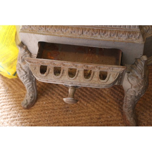 589 - A grey painted cast iron stove with pierced decoration, on cabriole supports, 19