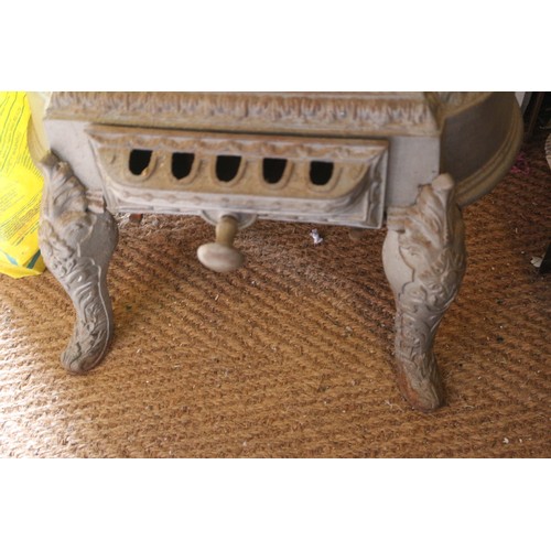 589 - A grey painted cast iron stove with pierced decoration, on cabriole supports, 19