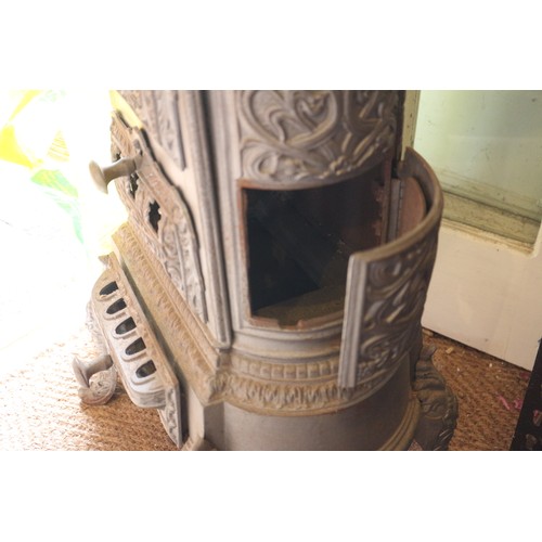 589 - A grey painted cast iron stove with pierced decoration, on cabriole supports, 19