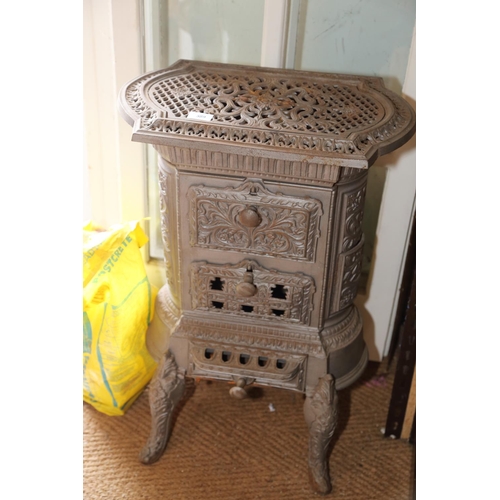 617 - A grey painted cast iron stove with pierced decoration, on cabriole supports, 19