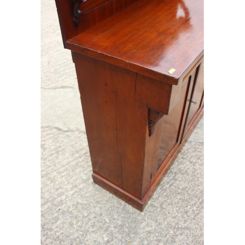 406 - A late 19th century mahogany ledge back chiffonier with frieze drawer over cupboards, on block base,... 