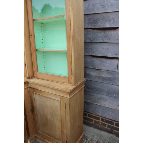 593 - A 19th century waxed pine breakfront bookcase/display cabinet enclosed four glazed doors over cupboa... 