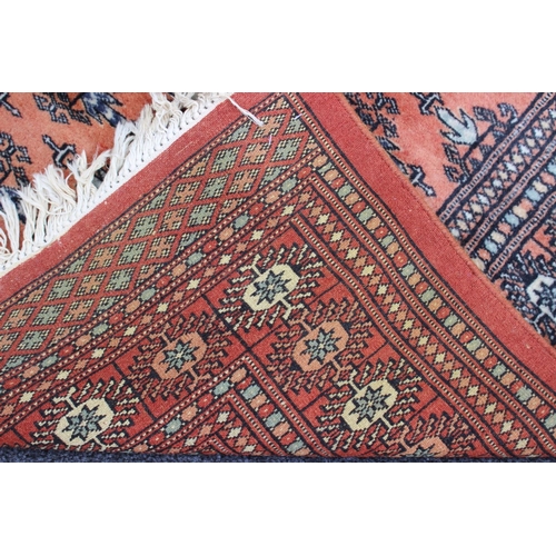 603 - A Bokhara rug of traditional design in shades of rust, red, blue and natural, 47